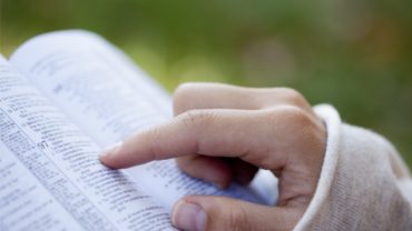 close-up-of-womans-hands-while-reading-the-bible-outside
