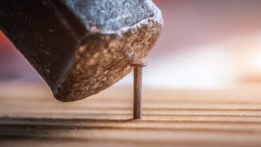 hammering-nail-into-board